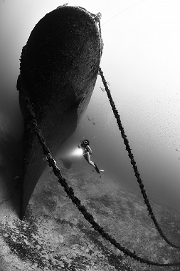 modella in mare dinanzi a un relitto, foto in bianco e nero