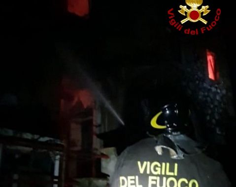 Pompiere in azione per domare l'incendio